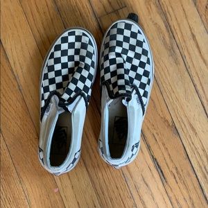 Worn black and white checkered slip on vans